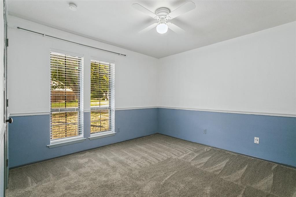 Neutral wall palette with chair rail molding, dual-pane windows, and ceiling fan with integrated lighting