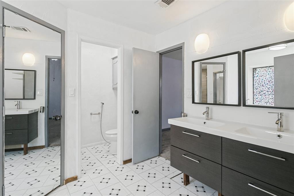 Dual-sink vanity with dark wood-finish cabinetry, rectangular vessel sinks, matte metallic faucets, and matching framed mirrors