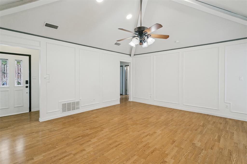 Vaulted ceilings, wainscoting wall paneling, wood-finish flooring, and a multi-lite glass entry door Vaulted ceilings, wainscoting wall paneling, wood-finish flooring, and a multi-lite glass entry door