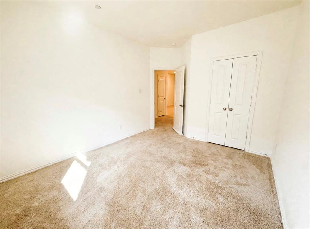 Neutral wall tones, carpeted flooring, and double-panel closet doors featuring brushed metallic hardware