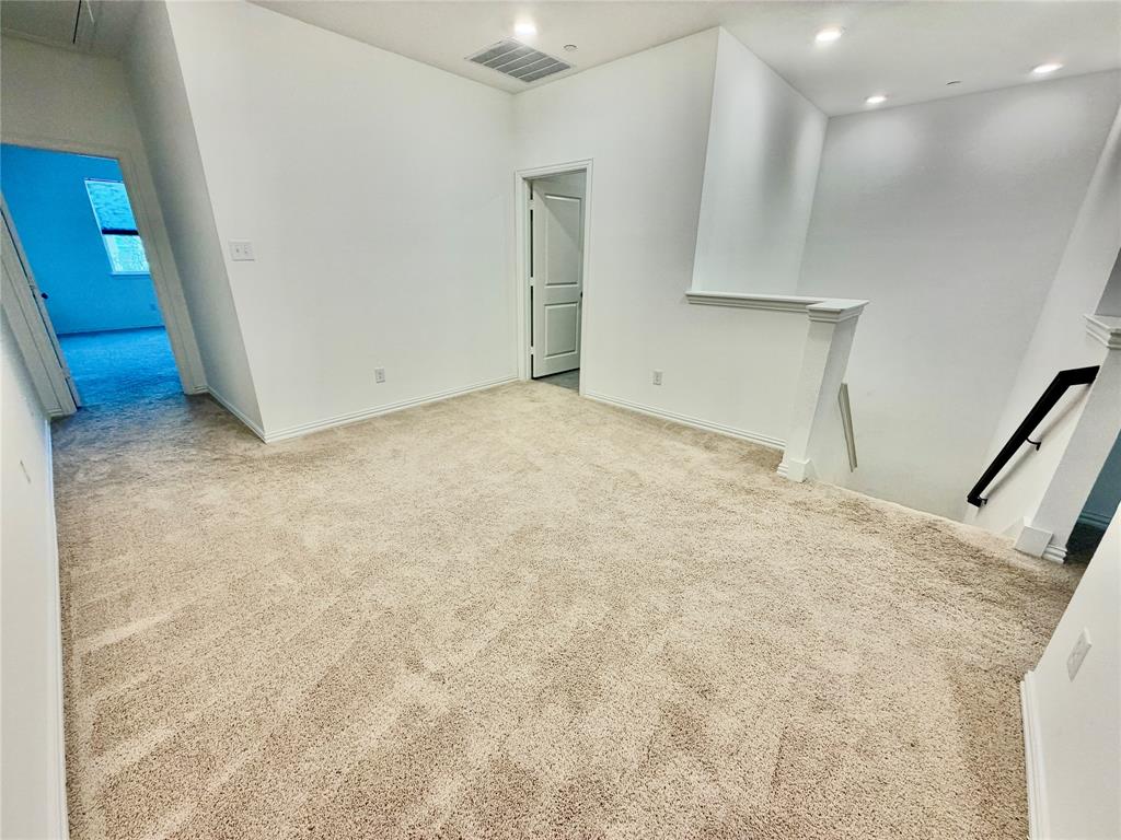 Neutral-toned carpeting, recessed ceiling lighting, and solid-core interior doors