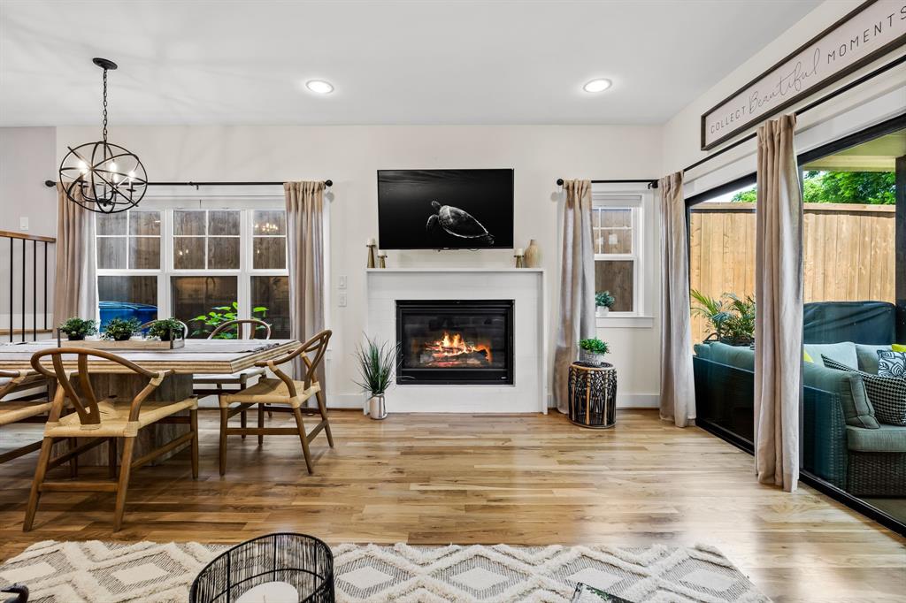 Living room with an inviting chandelier and light hardwood / wood-style flooring