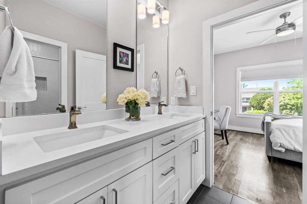 Bathroom featuring large vanity, double sink, ceiling fan, and hardwood / wood-style floors