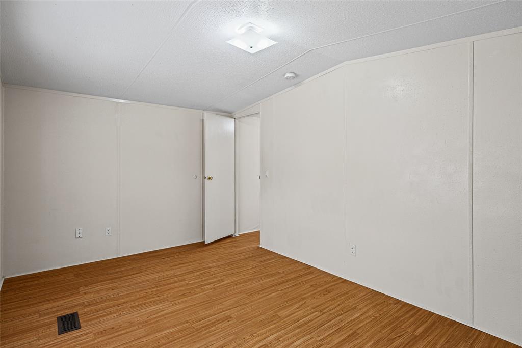 Interior room featuring wood-finish flooring, smooth white walls, and a central square flush-mount light fixture