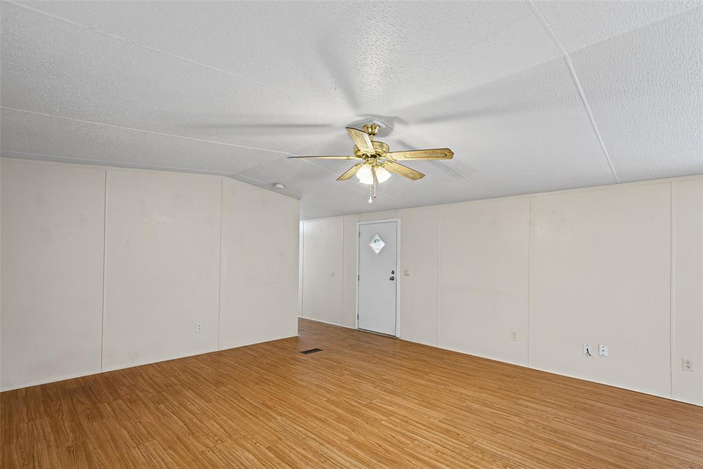 Interior space featuring wood-finish flooring, vaulted ceilings, and a ceiling fan with integrated lighting