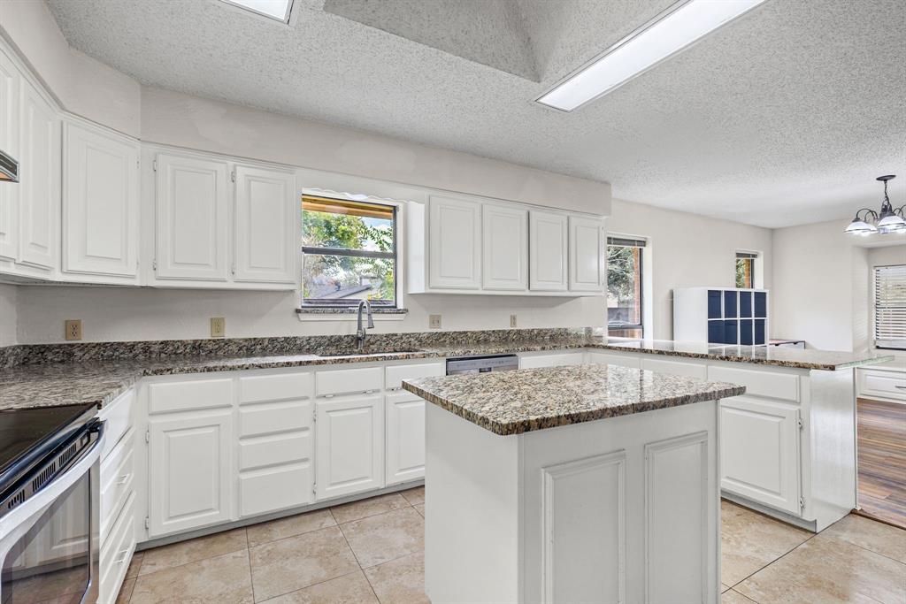 Kitchen featuring white cabinetry, stone-surface countertops, center island, tile flooring, and recessed ceiling lighting