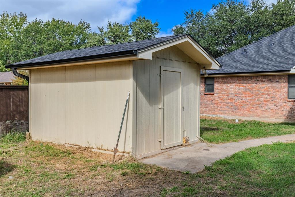 Detached storage structure featuring a gable roof, composite shingle roofing, and a concrete foundation