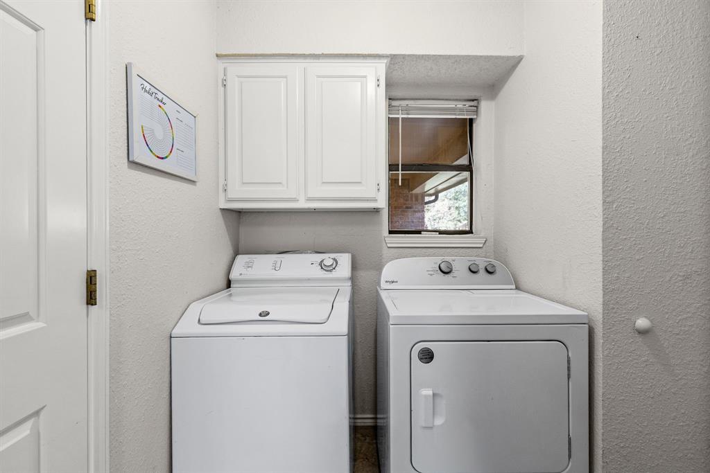 Laundry area featuring white shaker-style wall cabinetry and a window with horizontal blinds