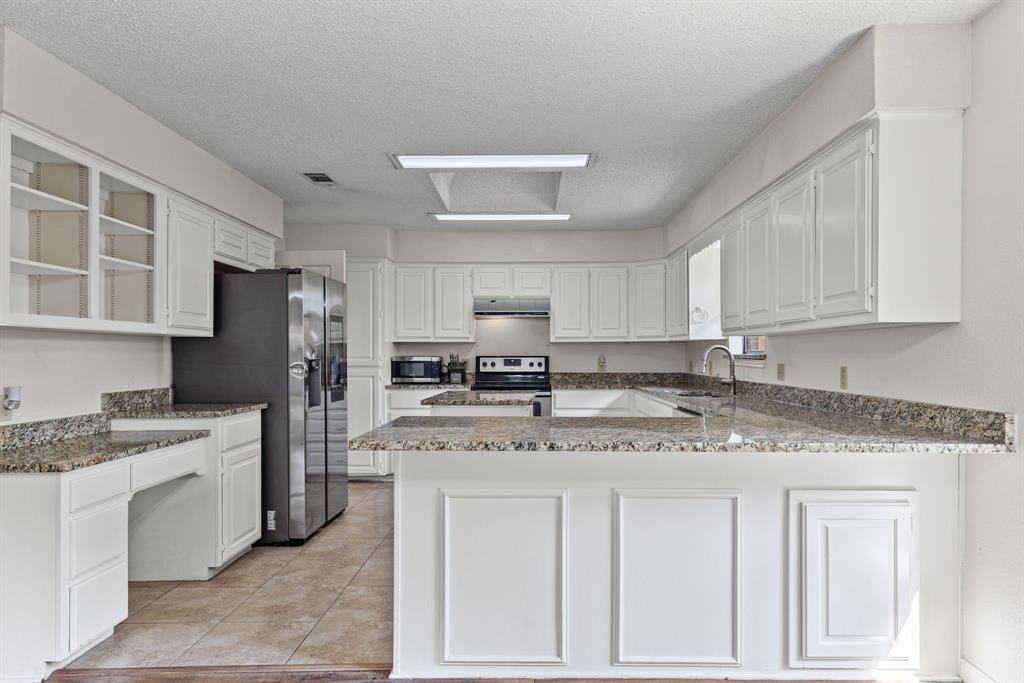 Kitchen featuring white cabinetry, stone-surface countertops, tile flooring, stainless steel side-by-side refrigerator, and recessed lighting