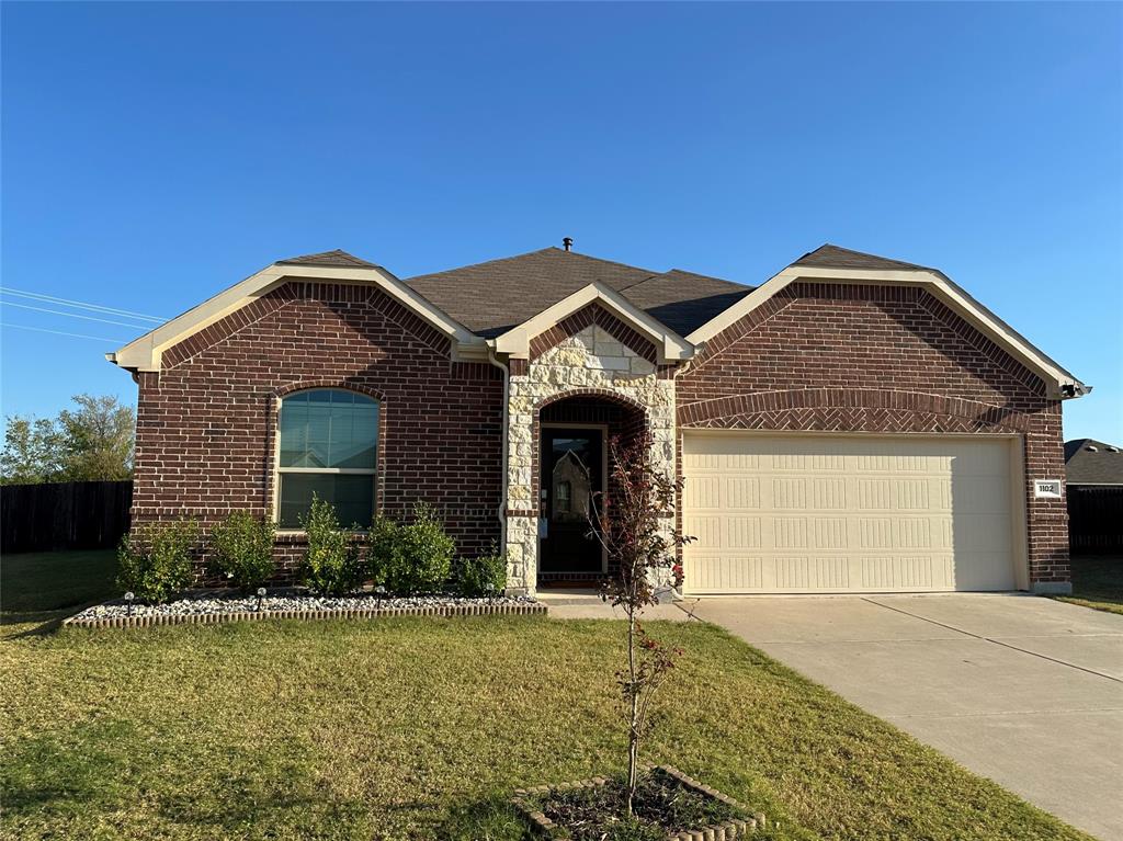 Brick and stone veneer facade featuring a multi-gabled roofline, arched window detailing, and a two-car garage Brick and stone veneer facade featuring a multi-gabled roofline, arched window detailing, and a two-car garage