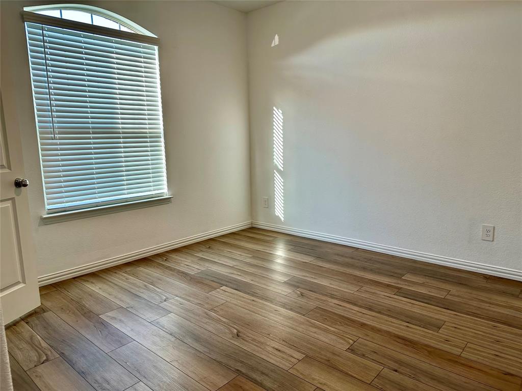 Entryway featuring wood-finish flooring, a solid black front door with a vertical frosted glass panel, and recessed ceiling lighting