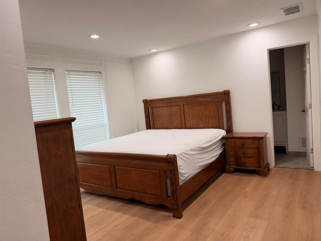 Room featuring wood-finish flooring, recessed lighting, and wall wainscoting Room featuring wood-finish flooring, recessed lighting, and wall wainscoting
