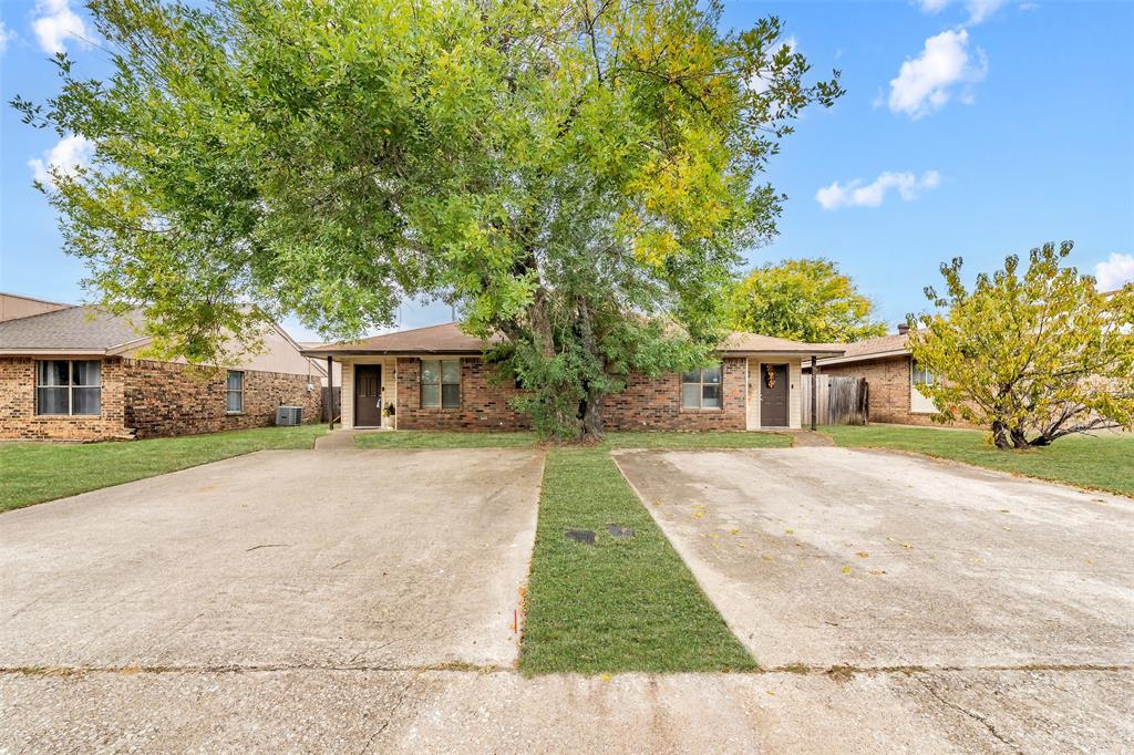 Brick exterior featuring a dual-unit configuration, concrete driveways, and mature landscaping Brick exterior featuring a dual-unit configuration, concrete driveways, and mature landscaping
