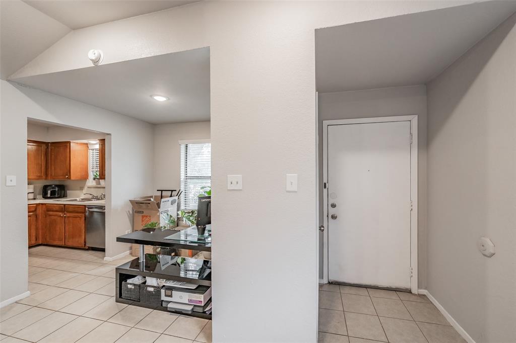1128 Neutral wall color, ceramic tile flooring, vaulted ceiling, and wood-finish kitchen cabinetry with integrated stainless steel appliances 1128 Neutral wall color, ceramic tile flooring, vaulted ceiling, and wood-finish kitchen cabinetry with integrated stainless steel appliances