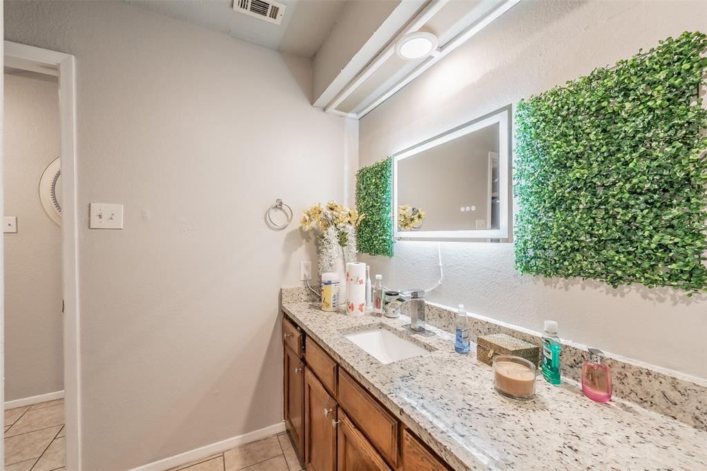1126 Vanity featuring stone-finish countertop, undermount sink, chrome faucet, and integrated mirror with perimeter illumination