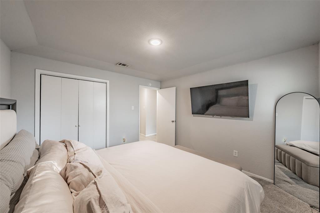 1128 Neutral-toned interior featuring carpeted flooring, recessed ceiling lighting, and a bi-fold closet door