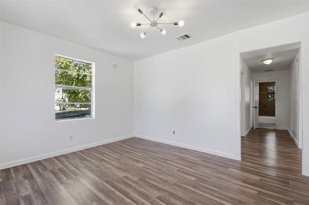 Room featuring wood-finish flooring, a modern multi-arm light fixture, and a large window