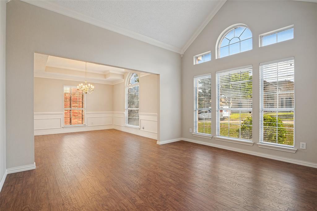 Vaulted ceilings with crown molding, wood-finish flooring, floor-to-ceiling windows with arched transoms, and classic wall wainscoting Vaulted ceilings with crown molding, wood-finish flooring, floor-to-ceiling windows with arched transoms, and classic wall wainscoting