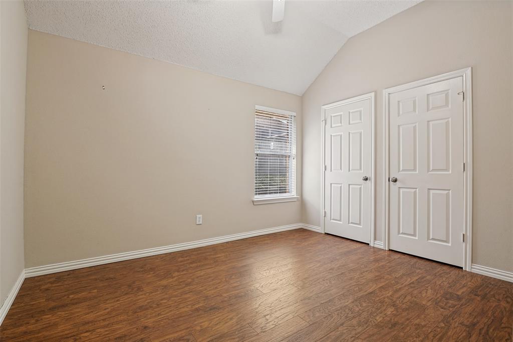 Vaulted ceiling, wood-finish flooring, and dual six-panel interior doors
