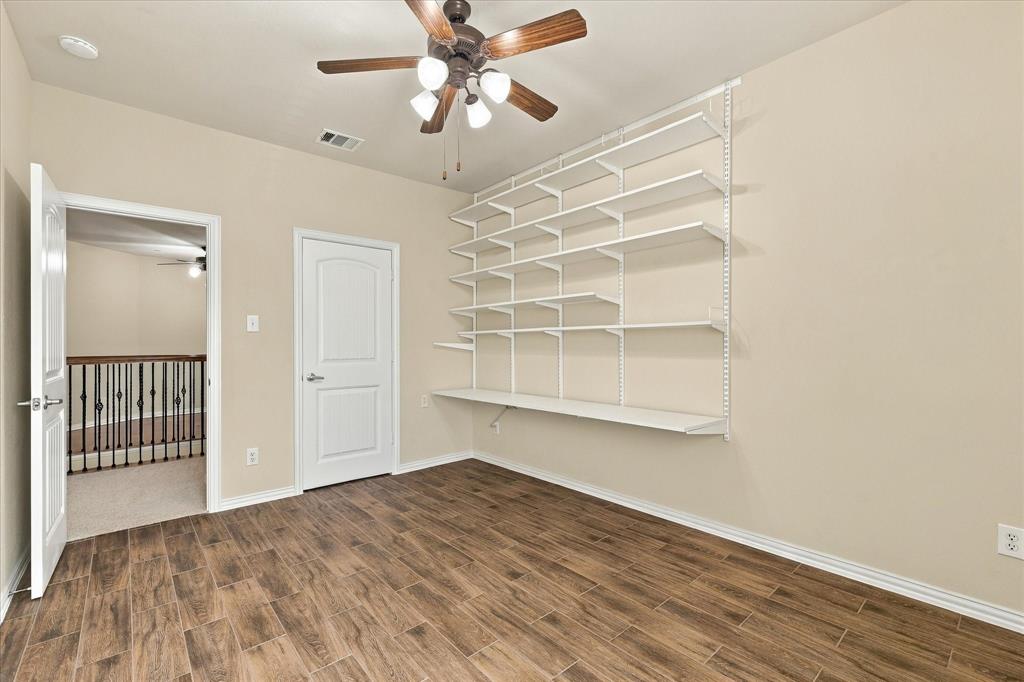Flexible secondary bedroom with attractive NEW wood like tile flooring and built-in shelving, ideal for home office, creative studio, additional bedroom, or guest retreat.