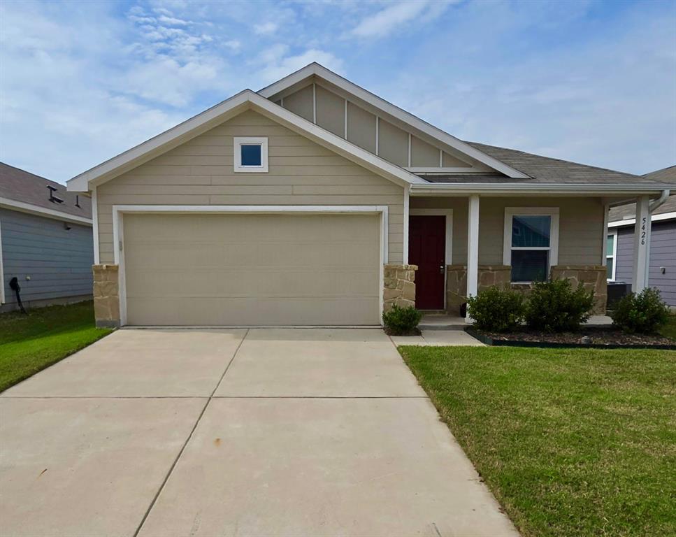 Single-story exterior featuring lap siding, stone veneer accents, a covered front entryway, and a concrete driveway Single-story exterior featuring lap siding, stone veneer accents, a covered front entryway, and a concrete driveway