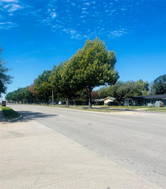 Concrete street featuring concrete sidewalks and mature trees