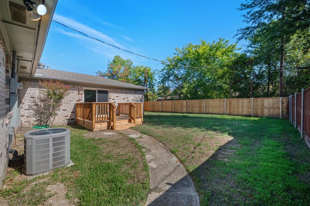 Brick exterior with a wood deck, concrete walkway, and fenced perimeter