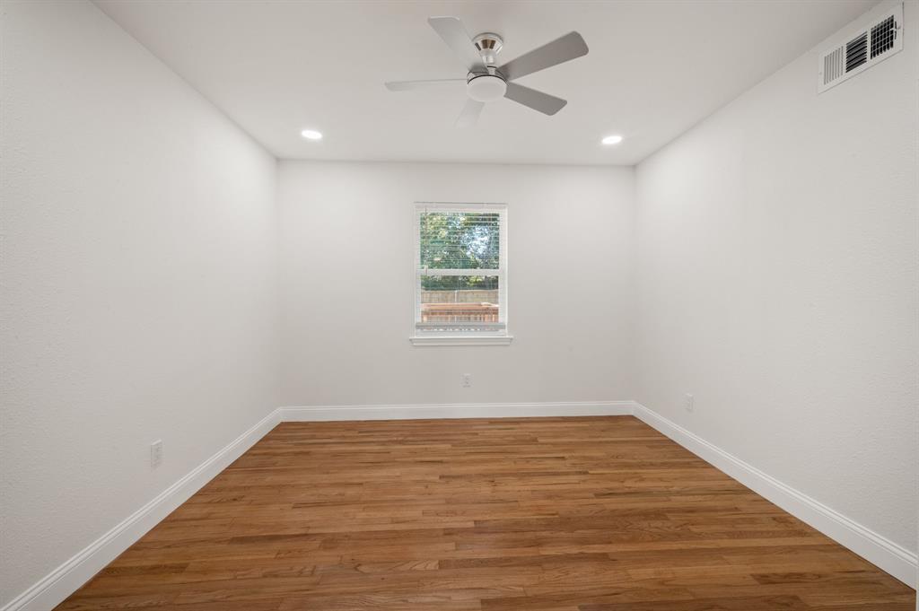 Room featuring wood-finish flooring, recessed lighting, a ceiling fan, and a centered window