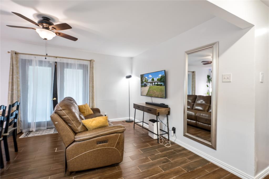 Wood-finish tile flooring, ceiling fan with integrated lighting, and glass-paned doors with exterior access Wood-finish tile flooring, ceiling fan with integrated lighting, and glass-paned doors with exterior access