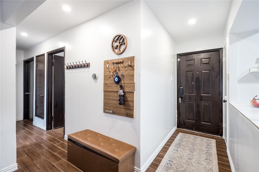 Entryway featuring dark-stained wood-finish flooring, recessed lighting, and a six-panel exterior door with integrated smart-lock hardware Entryway featuring dark-stained wood-finish flooring, recessed lighting, and a six-panel exterior door with integrated smart-lock hardware