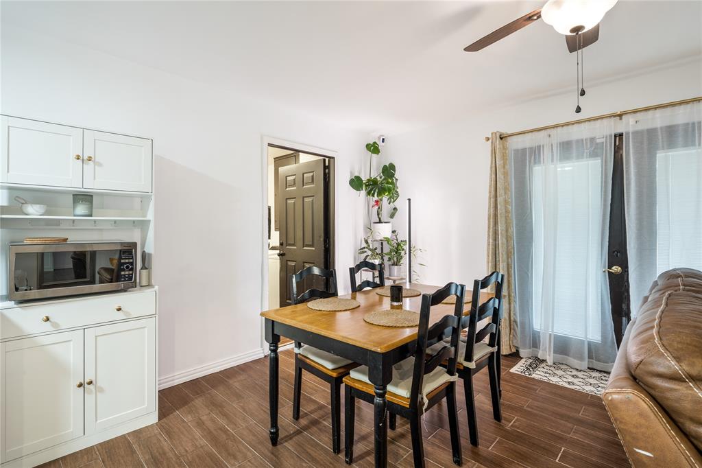 Built-in white cabinetry with open shelving, wood-finish flooring, and glass-paneled double doors leading to the exterior Built-in white cabinetry with open shelving, wood-finish flooring, and glass-paneled double doors leading to the exterior