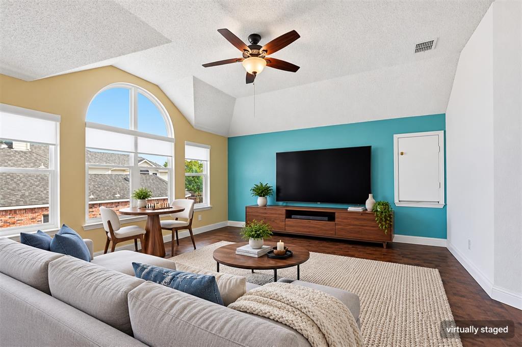 Virtually staged as a media and game room with comfortable seating, a large TV, and a chess table.