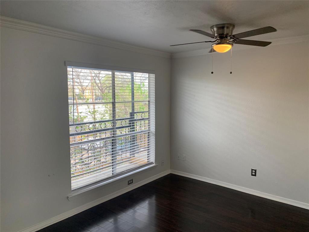 Dark wood-finish flooring, neutral wall tones, crown molding, a multi-pane window with installed blinds, and a brushed nickel ceiling fan with integrated lighting