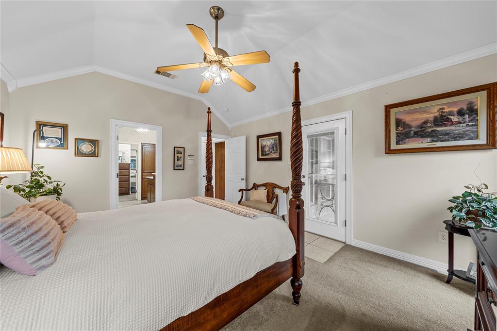 Vaulted ceilings, neutral wall tones, multi-light ceiling fan, and a glass-paneled exterior door