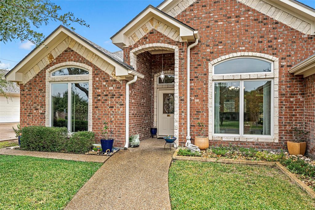 Traditional brick exterior featuring stone-accented gables, arched window detailing, and a covered entryway Traditional brick exterior featuring stone-accented gables, arched window detailing, and a covered entryway