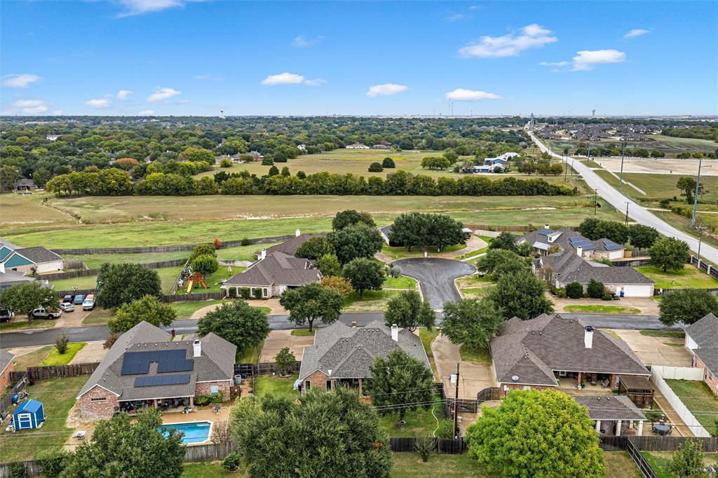 Aerial perspective of residential properties featuring solar panel arrays, private swimming pools, and manicured lawns