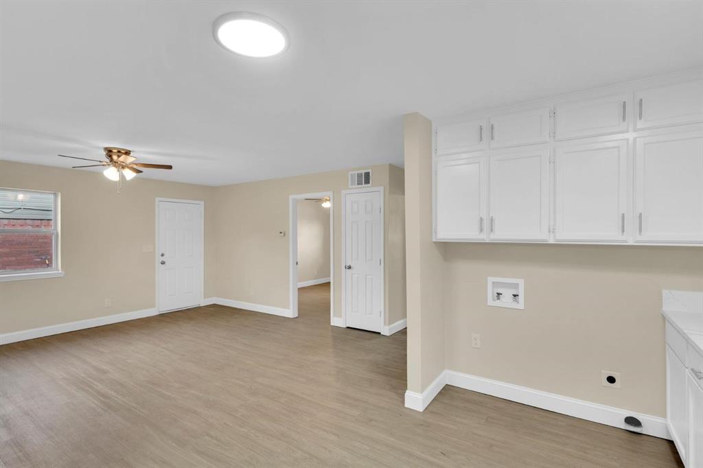 Utility area featuring white built-in cabinetry, wood-finish flooring, ceiling fan with light kit, and flush-mount ceiling lighting