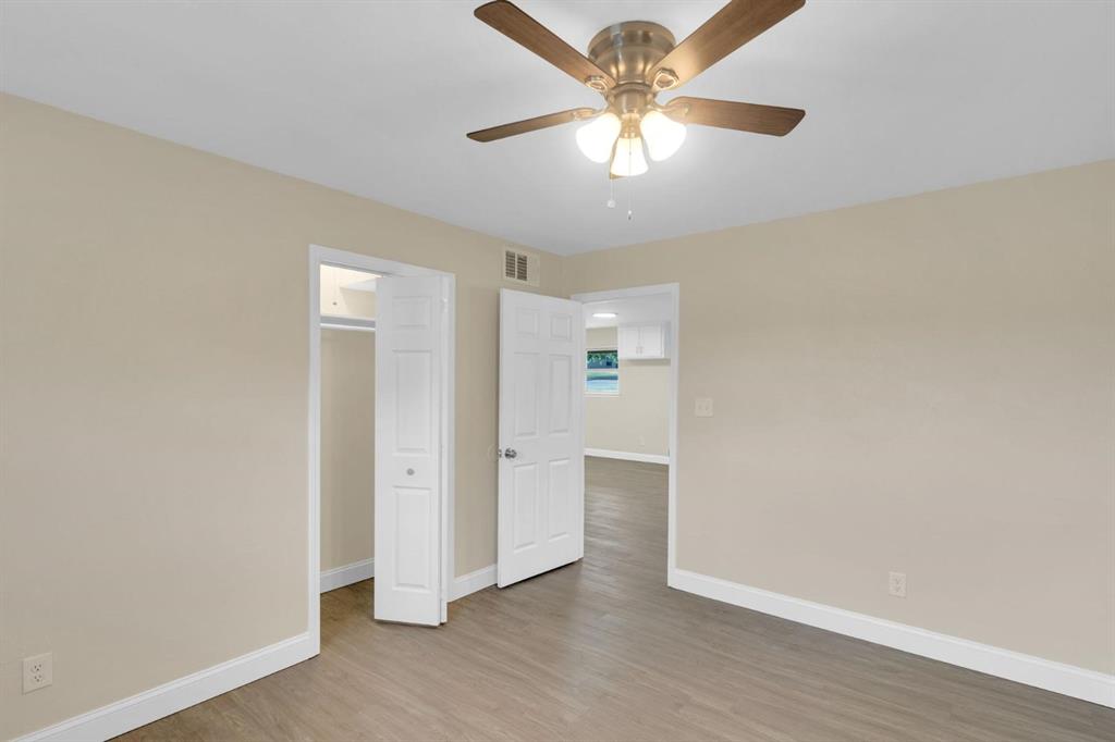 Interior space featuring wood-finish flooring, a ceiling fan with integrated lighting, and a closet with bifold doors