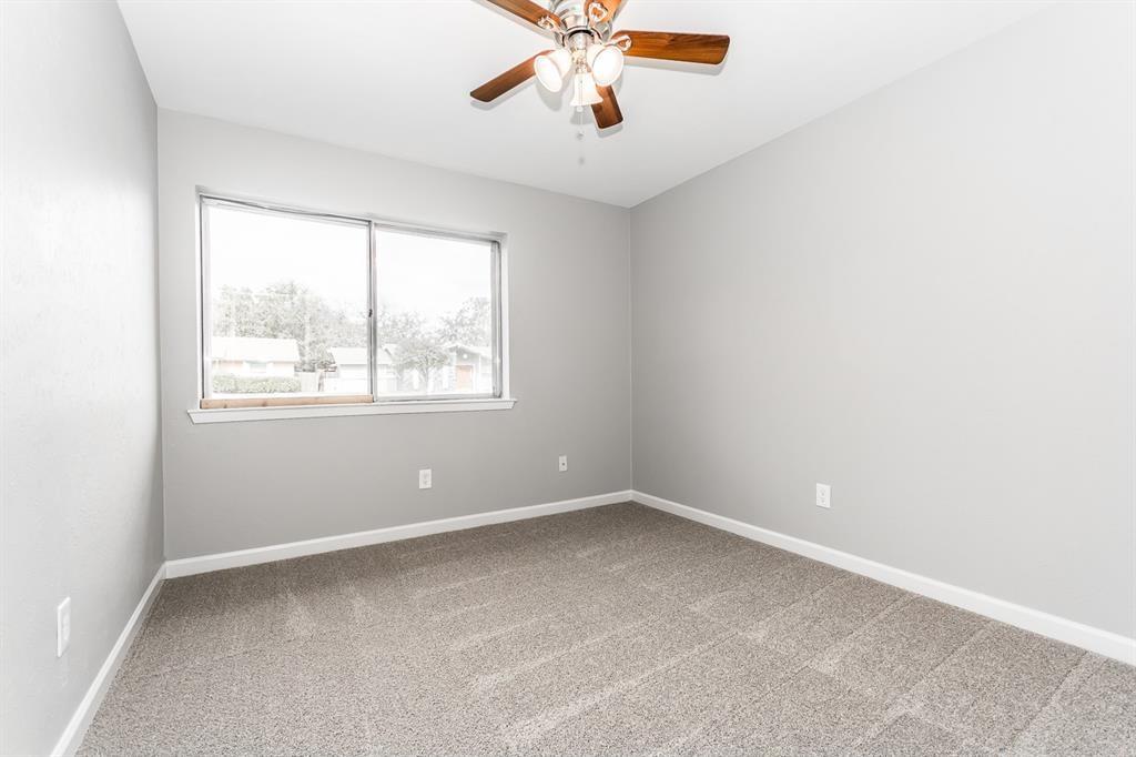 Neutral-toned walls, wall-to-wall carpeting, and a multi-blade ceiling fan with integrated lighting