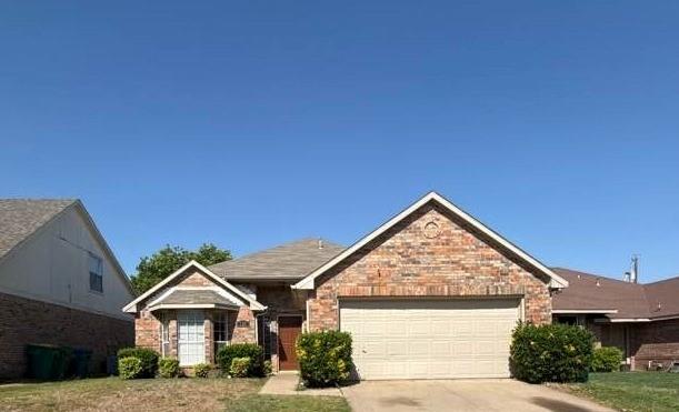 Single-story residence featuring a multi-textured brick exterior, a dual-gabled roofline, an attached two-car garage, and a front-facing bay window