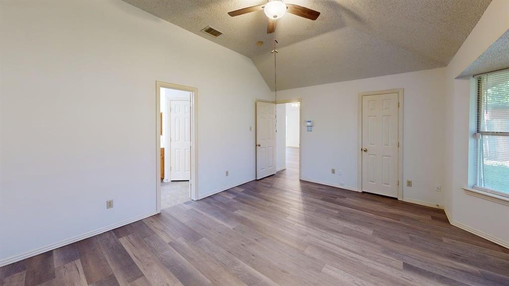 Vaulted ceiling featuring a central lighted ceiling fan, wood-finish flooring, and a recessed window area Vaulted ceiling featuring a central lighted ceiling fan, wood-finish flooring, and a recessed window area