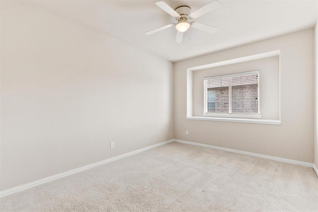 Neutral wall tones, carpeted flooring, recessed window nook, and ceiling fan with integrated lighting