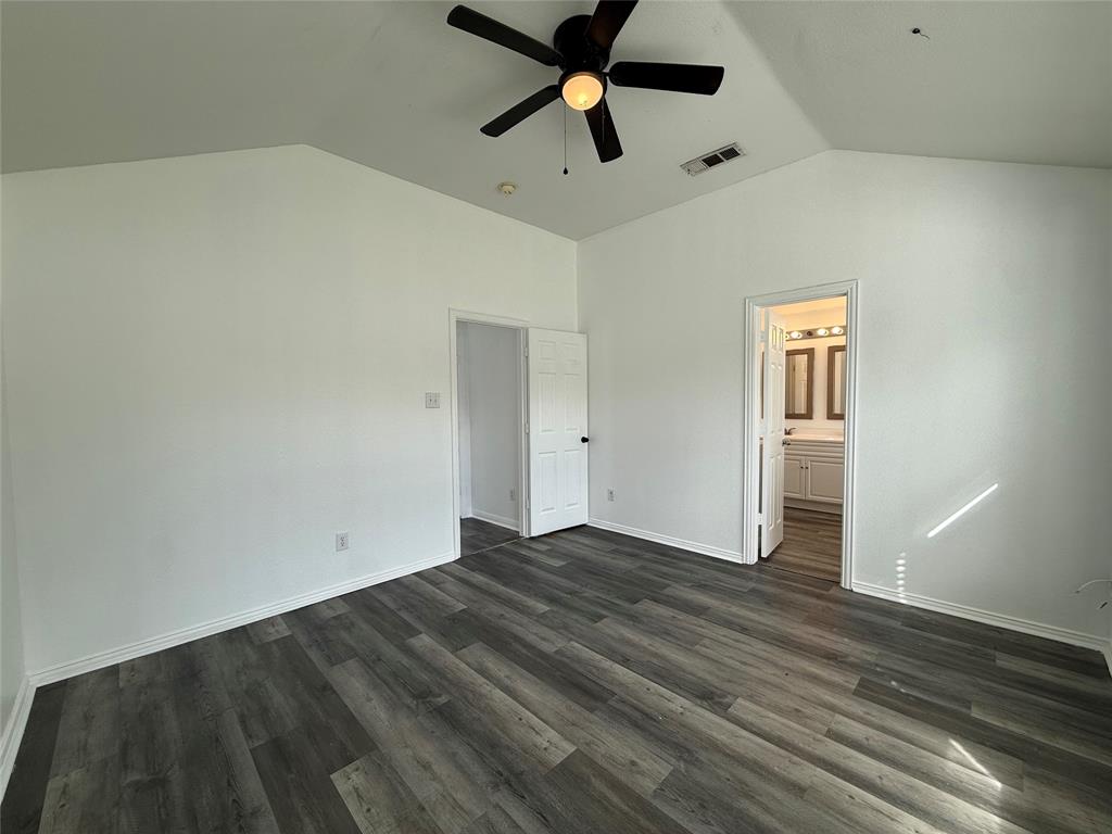 Vaulted ceiling featuring a central five-blade light fixture and durable wood-finish flooring