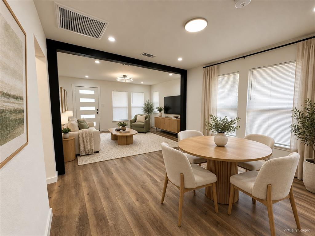 Wood-finish flooring, recessed lighting, and a bold black structural beam framing the room