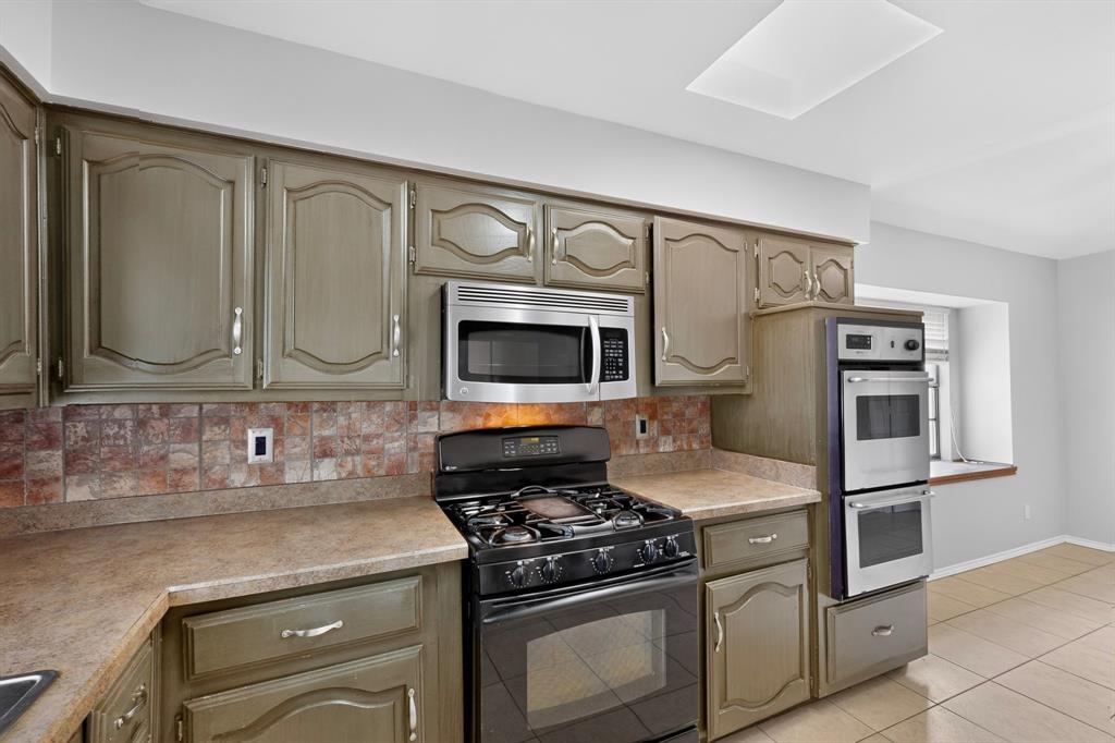 Kitchen featuring full-height cabinetry, tile backsplash, built-in stainless steel appliances, and a gas range Kitchen featuring full-height cabinetry, tile backsplash, built-in stainless steel appliances, and a gas range