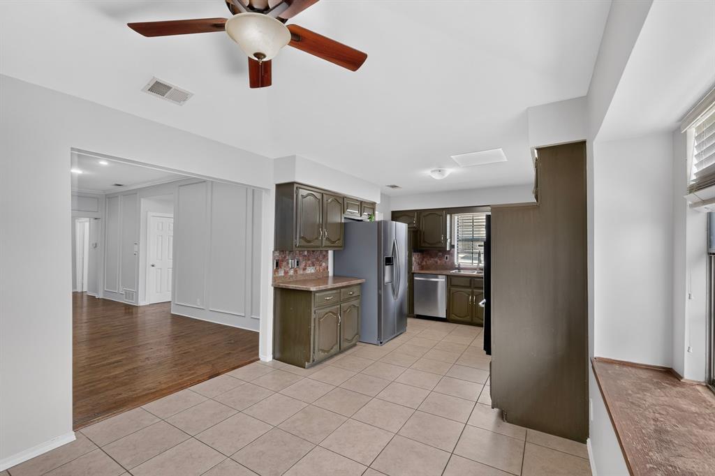 Kitchen featuring tile flooring, painted cabinetry, and stainless steel appliances Kitchen featuring tile flooring, painted cabinetry, and stainless steel appliances