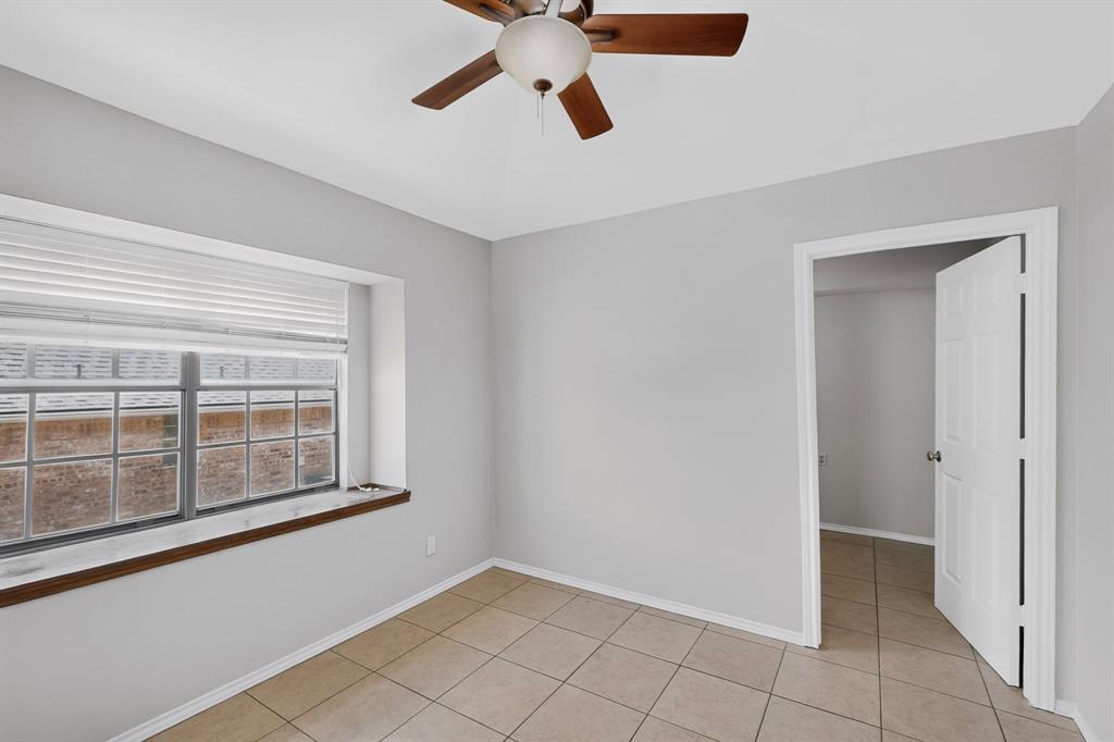 Neutral wall color, ceiling fan, window with horizontal blinds, tile flooring, and white trim