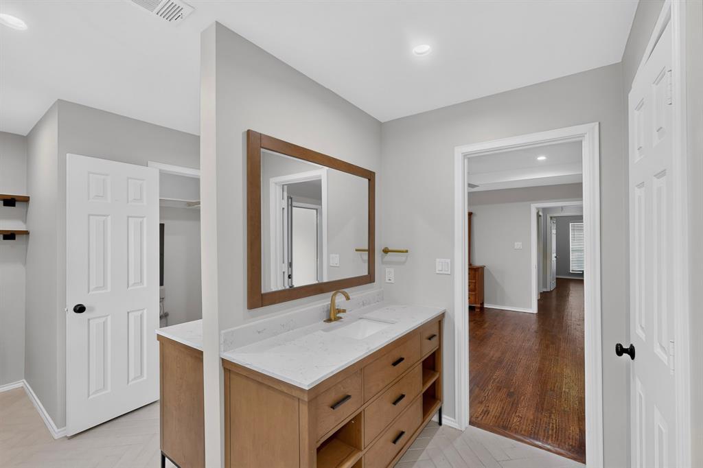 Wood-finish double sided vanity with white countertop and integrated sink