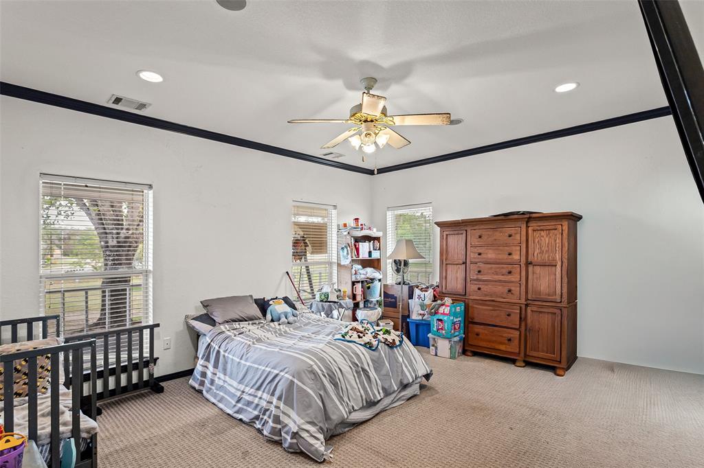 High ceilings featuring dark crown molding, recessed lighting, and a central ceiling fan