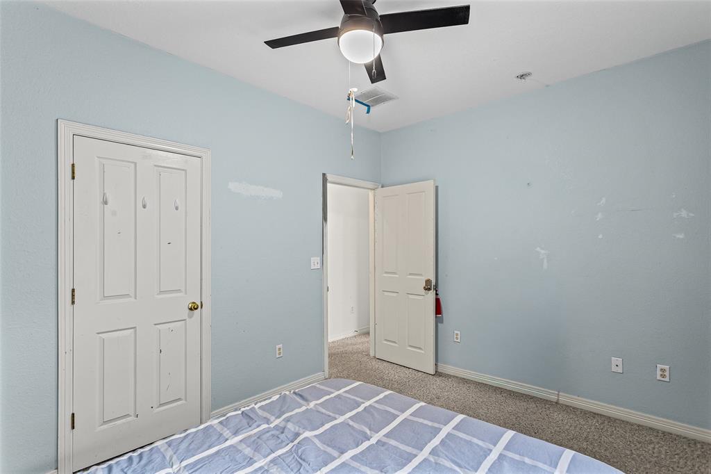 Textured wall finish, carpeted flooring, and a ceiling fan with integrated lighting